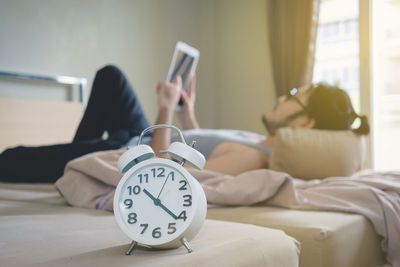 Midsection of man using mobile phone in bed