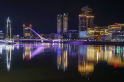 Illuminated buildings in city against sky at night