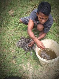 High angle view of man holding plant on field