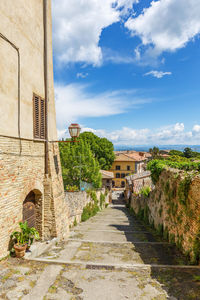 Alley amidst buildings in town against sky