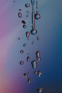 Close-up of bubbles over water against blue background