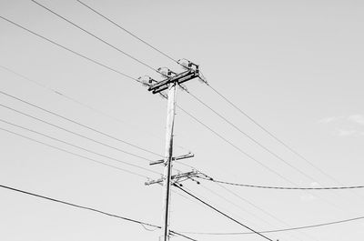 Low angle view of electricity pylon against clear sky