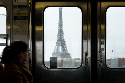Woman looking at eiffel tower through train window
