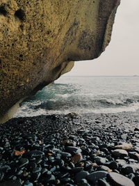 Pebbles on beach against sky