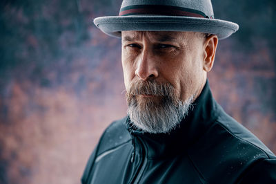 Older man with gray beard wearing a fedora