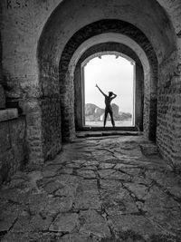Rear view of silhouette man standing at historical building