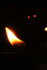 Close-up of lit candle in dark room