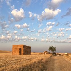 Hay bales on field against sky