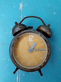 Directly above shot of weathered clock on blue table