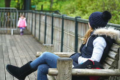 Rear view of smiling girl sitting outdoors