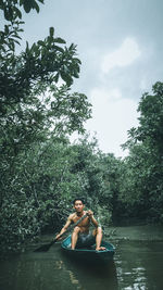 Shirtless man in lake against sky