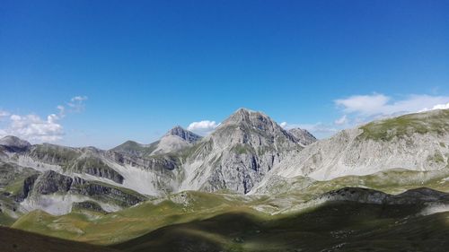 Scenic view of mountain range against cloudy sky