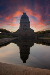 Reflection of building on lake during sunset