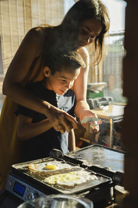 Side view of woman preparing food at home