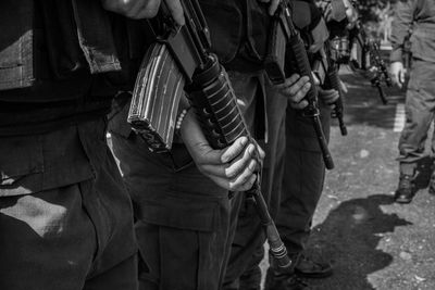 Army soldiers holding guns while standing outdoors