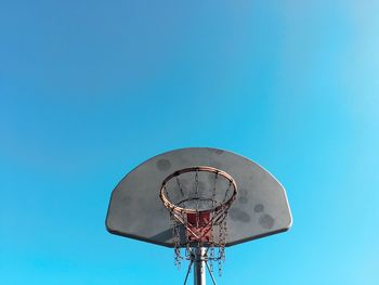 Low angle view of basketball hoop against clear blue sky