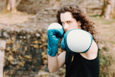 Portrait of man practicing boxing outdoors