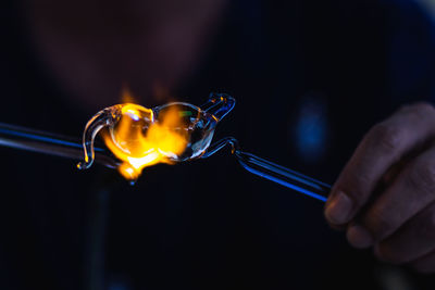 Midsection of person holding burning candles