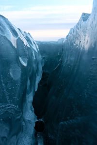 Close-up of icicles on mountain against sky