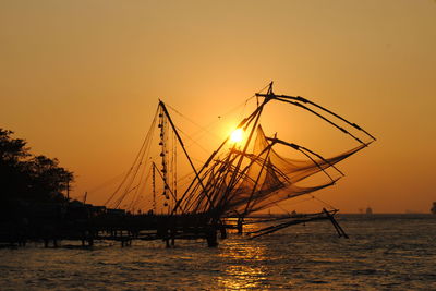 Side view of boats in sea at sunset