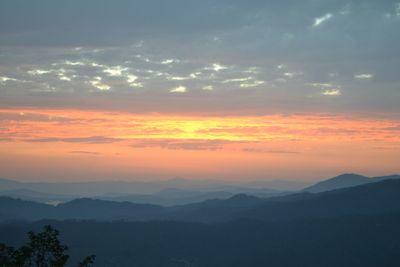 Scenic view of silhouette mountains against sky at sunset