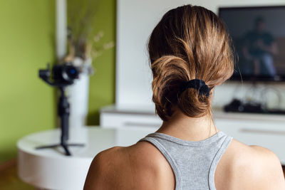 Rear view of woman standing at home