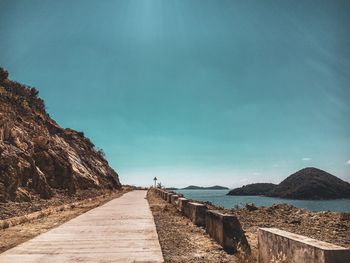 Footpath by sea against sky