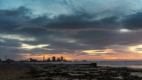 Scenic view of sea against dramatic sky during sunset