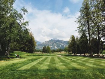 Scenic view of golf course against mountain peak