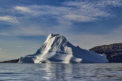 Scenic view of sea and snowcapped mountain against sky