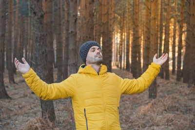 A man breathes fresh air in the forest. enjoying freedom in nature person