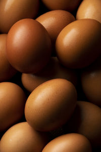 Red hen eggs on dark rustic table, organic food ingredients