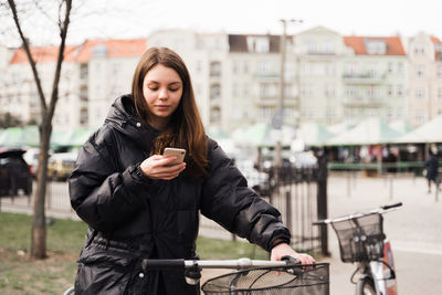 Smiling young woman using smart phone