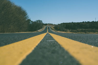 Surface level of road against clear sky