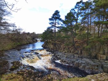 Scenic view of waterfall against sky