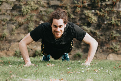 Full length of man exercising on grass