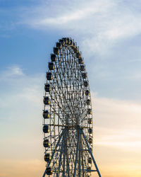 Low angle view of ferris wheel against sky during sunset