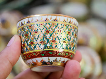 Close-up of hand holding ceramic tea cup