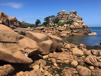 Rock formations by sea against sky