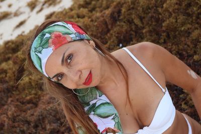 High angle portrait of seductive woman wearing bikini top at beach