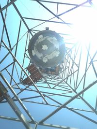 Low angle view of electric lamp hanging against sky