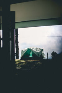 Houses against sky seen through window