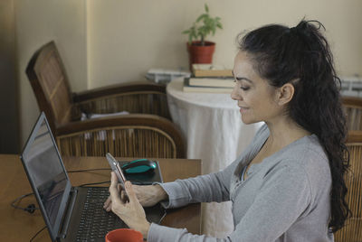 Side view of woman using mobile phone