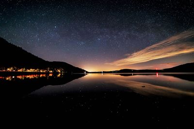 Scenic view of lake against sky at night