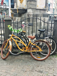 Bicycle parked on footpath against building