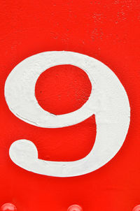 Vintage hand-painted number nine white on red painted metal with rivets