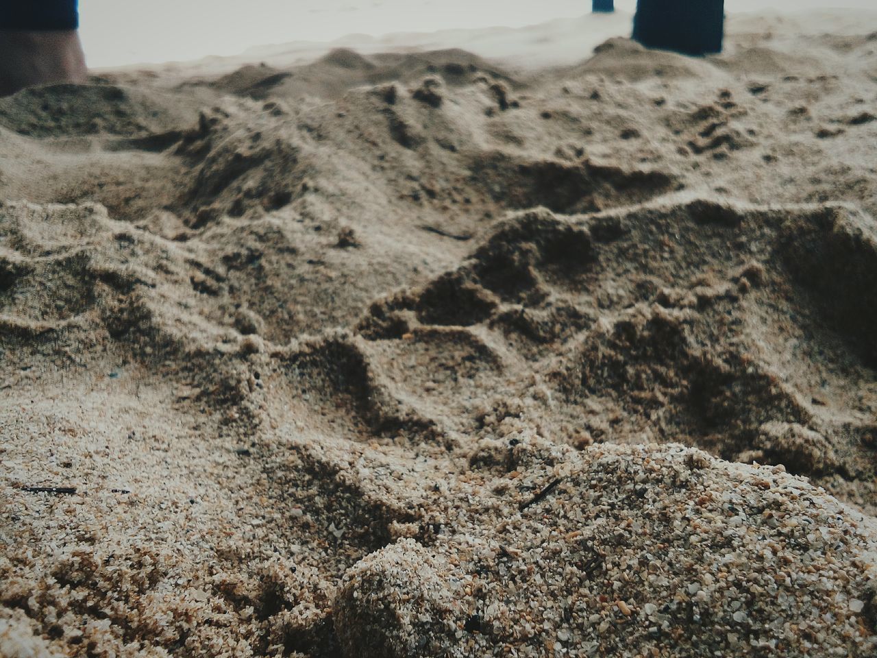 HIGH ANGLE VIEW OF FOOTPRINTS ON SANDY BEACH