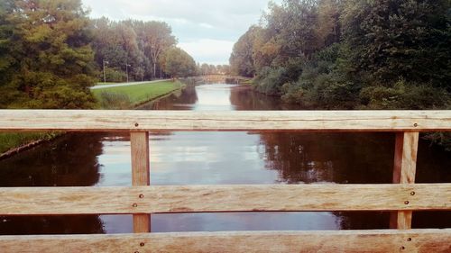 Footbridge over river against sky