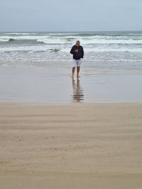 Rear view of woman walking at beach