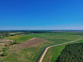 Scenic view of agricultural field against blue sky